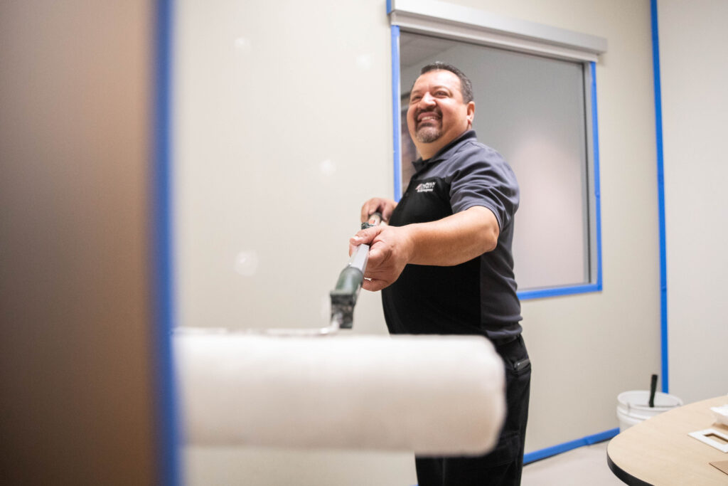 Vicente Zuniga with a paint roller